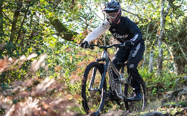 Passionné de vélo en train de descendre un chemin sur un VTT équipé de moyeux AIVEE